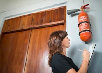 Young woman fire inspector writes in office