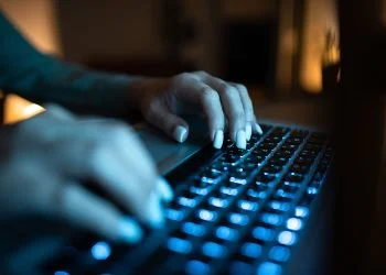 Businesswoman Typing Recent Updates On Lap Top Keyboard On Desk.