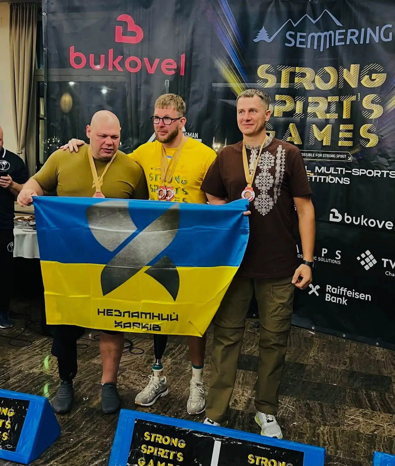 Три спортсмени тримають синьо-жовтий український прапор Сильні Переяслава