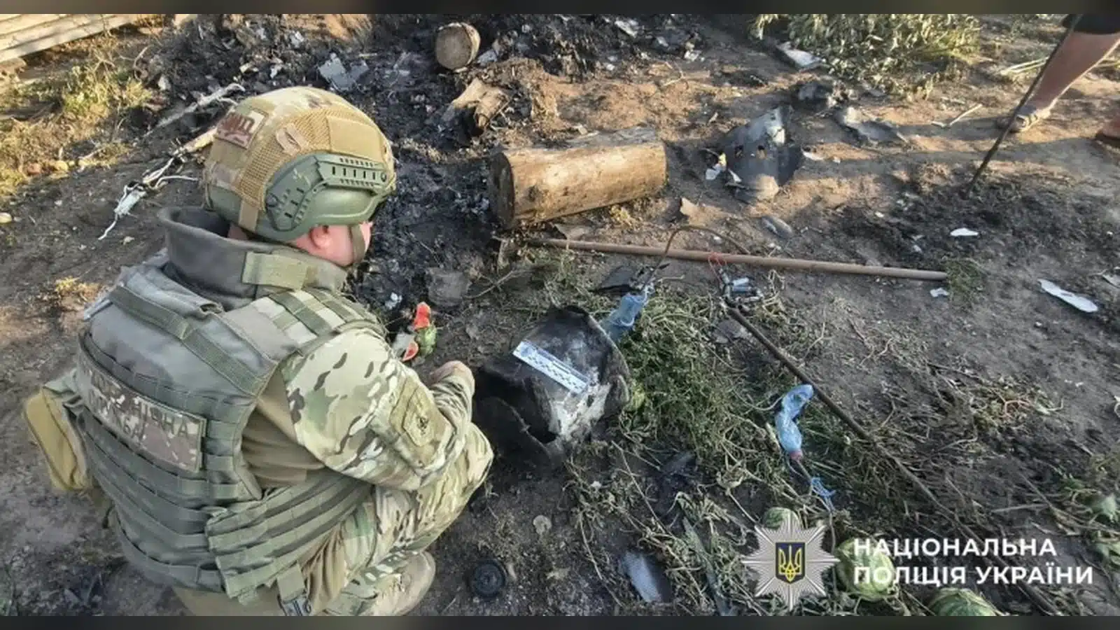 Вибухотехнік поліції оглядає бойову частину збитого дрона, виявлену у дворі приватного будинку на Бориспільщині