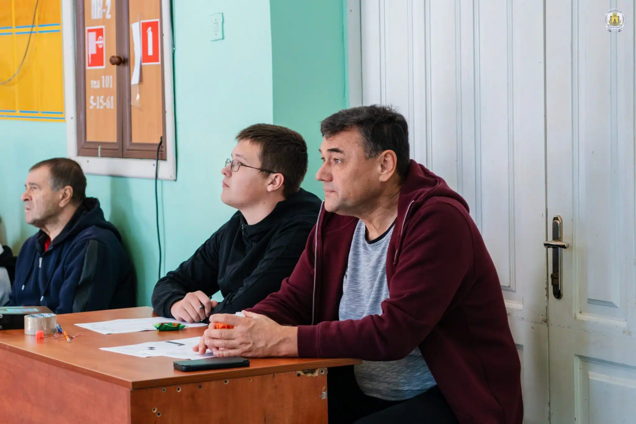 Судді і організатори змагань сидять за столом під час турніру в спортивному залі